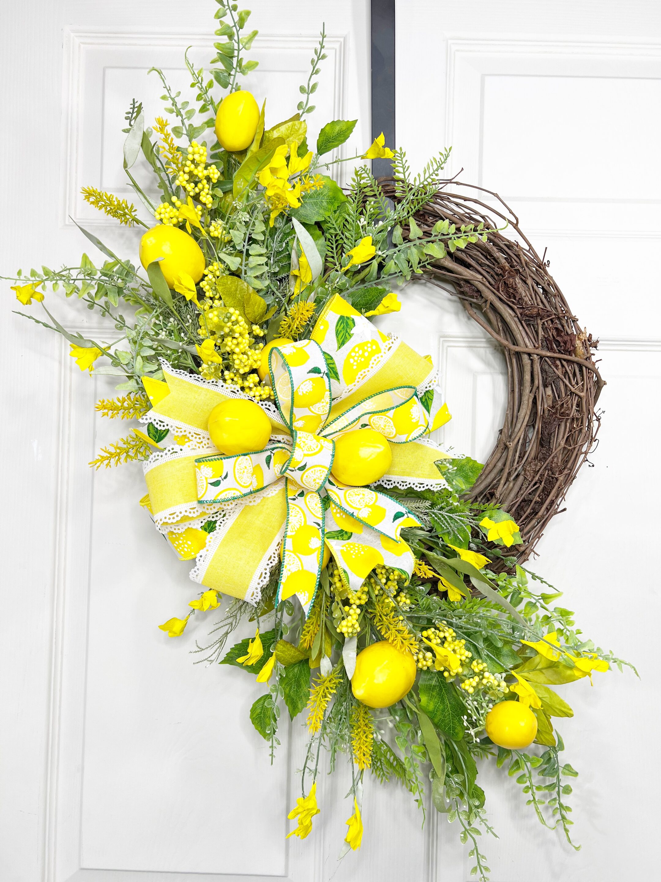 bright wreath with faux lemons, multi-ribbon bow on a grapevine wreath