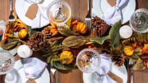 Thanksgiving table decor with orange and dark green color palette