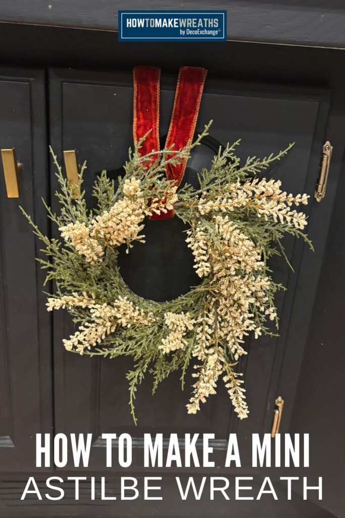 Close-up of an astilbe mini wreath made with soft cream florals and cedar greenery.
