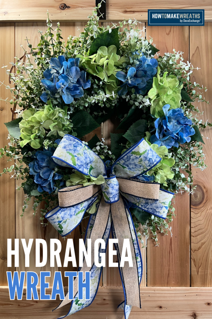 spring hydrangea wreath with blue and green flowers, eucalyptus greenery, and a burlap and floral ribbon bow