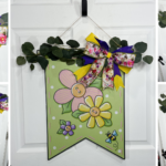 Multi-angle collage showing a spring flag door hanger with eucalyptus garland and a layered floral, yellow, and purple ribbon bow, tutorial from HowToMakeWreaths.com by DecoExchange