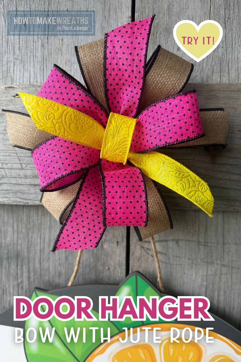 A close-up of a layered door hanger bow made with hot pink polka dot, yellow embossed, and natural burlap ribbon, secured at the center with yellow ribbon and attached to a citrus wood sign using jute rope, displayed against a gray wood fence.