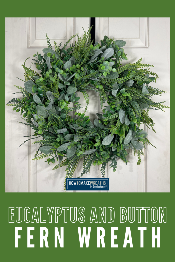 Full eucalyptus and button fern wreath hanging on a white paneled front door, with text reading "Eucalyptus and Button Fern Wreath"